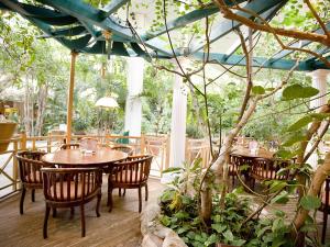 een restaurant met houten tafels en stoelen en bomen bij Hotel Bispinger Heide by Center Parcs in Bispingen