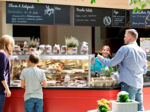 a man and a child ordering food at a bakery at Hotel Bispinger Heide by Center Parcs in Bispingen
