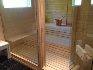 a wooden sauna with a bucket in the middle at Country House by the lake in Hästveda +33 photos