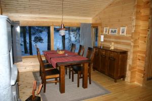 a dining room with a table and chairs in a cabin at Mökki Lahtela in Puumala