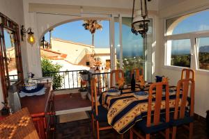 a dining room with a table and chairs and a window at EOLE in Benissa