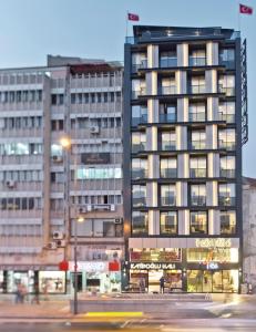 un grand bâtiment avec un éclairage de rue devant lui dans l'établissement Hotel 86 By Katipoğlu, à Izmir