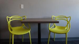 twee gele stoelen rond een houten tafel en een tafel en twee stoelen bij The Place at Port Aransas in Port Aransas