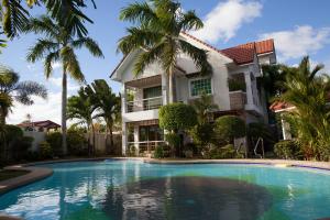 a house with a swimming pool in front of a house at Sir Nico Guesthouse and Resort in Plaridel