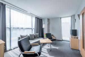 a hotel room with chairs and a couch and a tv at Weiser Hotel in Wrocław