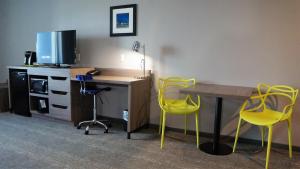 a room with a desk and yellow chairs and a table at The Place at Port Aransas in Port Aransas