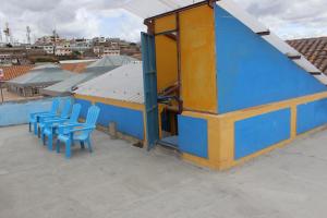 a blue building with blue chairs on a roof at Hostal Café Tiana in Latacunga
