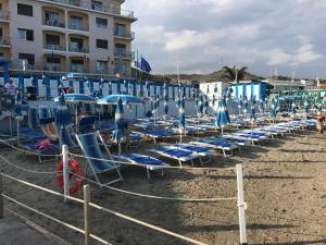 een stel stoelen en parasols op een strand bij Soggiorno Marino San Giuseppe in Imperia