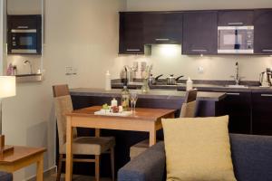 a kitchen and dining room with a table and chairs at PREMIER SUITES Manchester in Manchester