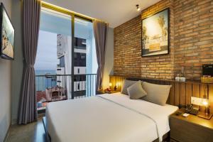 a bedroom with a white bed and a large window at Marilyn Boutique Hotel Nha Trang in Nha Trang