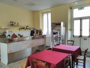 a restaurant with two tables and a kitchen with a counter at Soggiorno Marino San Giuseppe in Imperia