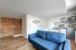 ein blaues Sofa im Wohnzimmer mit Küche in der Unterkunft My Toul'House SPA in Toulouse