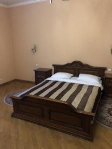 1 Schlafzimmer mit einem großen Holzbett und 2 Tischen in der Unterkunft Europe Hotel Brody in Brody