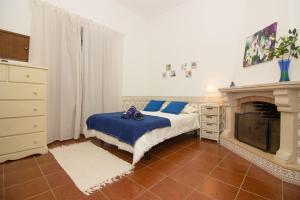 ein Schlafzimmer mit einem Bett und einem Kamin in der Unterkunft Casa da Vila Alta in Alenquer
