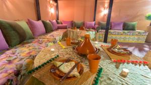 a couch with a table with plates of food on it at Riad Ramz in Marrakesh