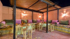 ein Restaurant mit Tischen und Stühlen in einem Zimmer in der Unterkunft Riad Ramz in Marrakesch