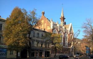 a large building with a steeple on a city street at Pastera apartments. in Odesa