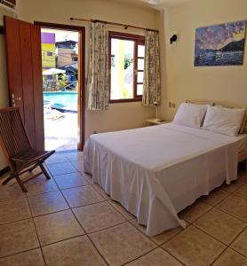 イーリャ・グランデにあるPousada Só Naturezaのベッドルーム1室(ベッド1台付)、スライド式ガラスドアが備わります。