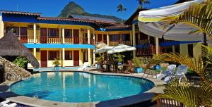 a swimming pool in front of a building with a resort at Pousada Só Natureza in Abraão