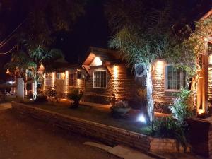 a brick house with lights on it at night at Apart Hotel Piscu Yaco in Merlo