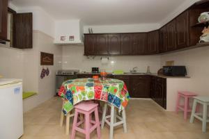 アレンケルにあるCasa da Vila Altaのキッチン(テーブル、ピンクのスツール付)
