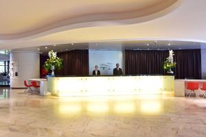 2 hommes se tenant derrière un comptoir de réception dans le hall dans l'établissement Pestana Casino Park Hotel & Casino, à Funchal