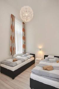 ブダペストにあるNew, high quality apartment in the city centerのベッドルーム(ベッド3台、シャンデリア付)