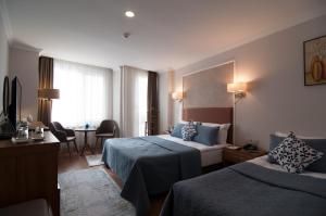 a hotel room with two beds and a table at Nomade Hotel Exclusive in Istanbul