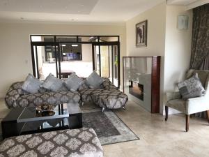 a living room with a couch and a chair at Coral Beach Bed & Breakfast in East London