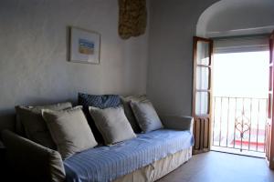 Sofá con almohadas en una habitación con ventana en Casa El Patio, en Vejer de la Frontera