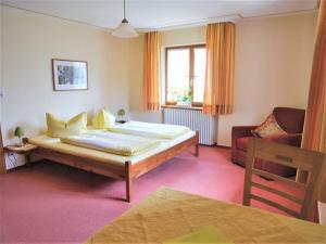 a bedroom with a bed and a couch and a chair at Schnurrenhof in Seebach