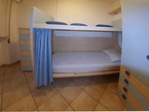 リニャーノ・サッビアドーロにあるAlidecoの青いカーテンが備わる客室で、二段ベッド2台が備わります。