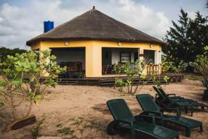 a small hut with green chairs in front of it at Bees Mouth Gambia in Sanyang