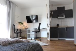 um quarto com uma cozinha e uma mesa com cadeiras em Apartment Sudermann em Ludwigshafen am Rhein