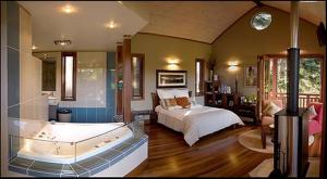 um quarto com uma cama e uma banheira em Cottage In The Woods - Formerly King Ludwigs Cottage em Maleny