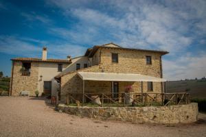 a stone house with an umbrella in front of it at Agriturismo San Silvestro in Marsciano