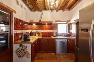 a kitchen with a refrigerator and a counter top at Villa Can Coves in Sant Miquel de Balansat