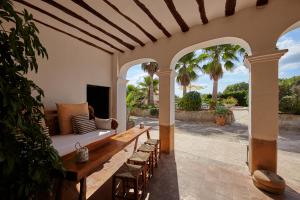 patio con divano e sedie sotto il portico di Villa Can Coves a Sant Miquel de Balansat