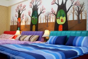 a bedroom with a bed with trees painted on the wall at Miaoli Sanyi Bo Wu Guan Homestay in Sanyi
