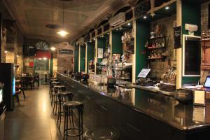 a bar in a restaurant with green walls and stools at Hostal Siglo XIX in Cacabelos