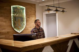 a man standing in front of a reception desk at Клуб Яремчанський in Yaremche