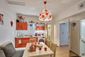 eine Küche mit orangefarbenen Schränken und einem Tisch mit Obst darauf in der Unterkunft Apartment U Medvídka in Karlsbad