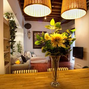 un jarrón de flores sobre una mesa en la sala de estar en Toledo Con Encanto, en Toledo