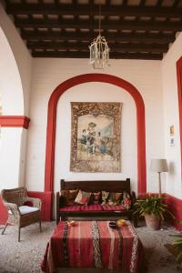 1 dormitorio con 1 cama y una pintura en la pared en La Carreña, en Jerez de la Frontera