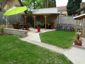 eine Terrasse mit einem Tisch und einem grünen Sonnenschirm in der Unterkunft L' éscale de la Besbre in Vaumas