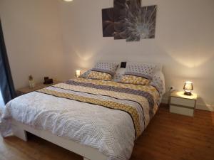 a bedroom with a large bed with two lamps on it at L' éscale de la Besbre in Vaumas