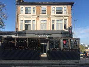 a building on a city street with a store at PubLove @ The Crown, Battersea in London