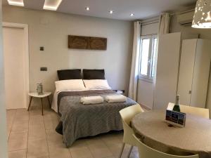 a bedroom with a bed and a table and chairs at Apartamentos Can Quim in L'Escala