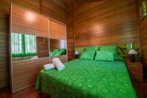 a bedroom with a green bed and a mirror at Casa El Mirador in Teruel