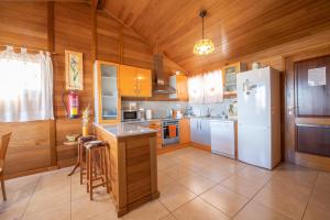 a kitchen with wooden cabinets and a white refrigerator at Casa El Mirador in Teruel